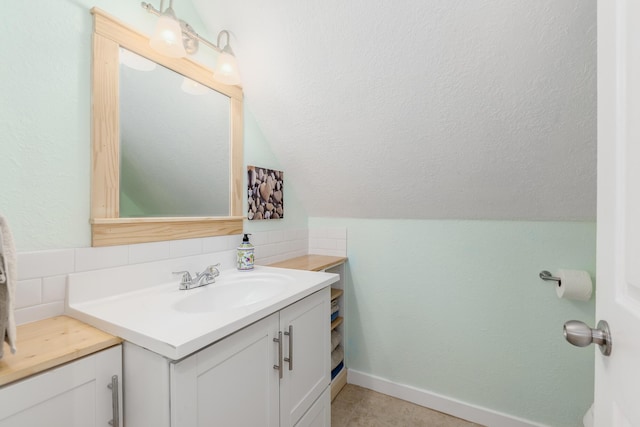 bathroom with decorative backsplash, vanity, and vaulted ceiling