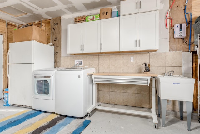 clothes washing area featuring cabinets and separate washer and dryer