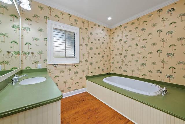 bathroom featuring crown molding, hardwood / wood-style flooring, a bath, and vanity