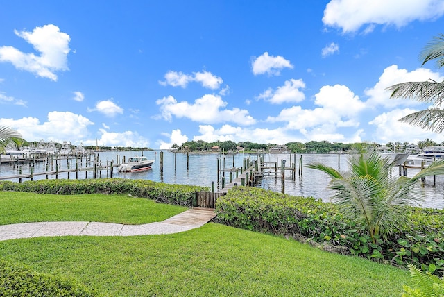 view of dock with a lawn and a water view