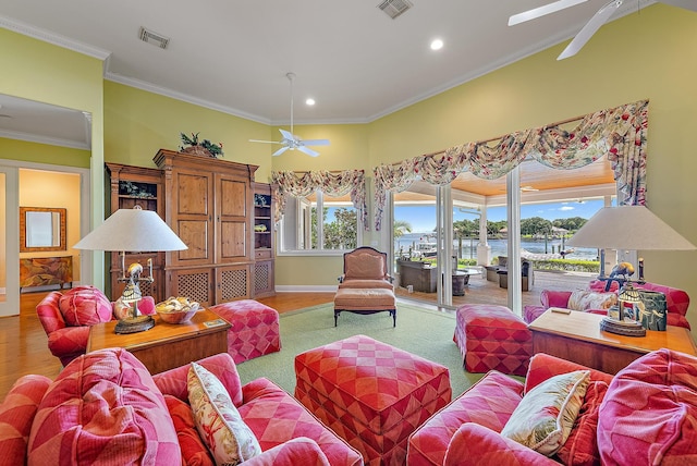 living room featuring ceiling fan, light hardwood / wood-style flooring, and crown molding