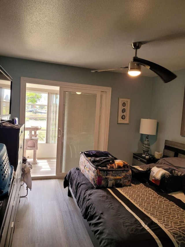 bedroom featuring ceiling fan, wood-type flooring, and a textured ceiling