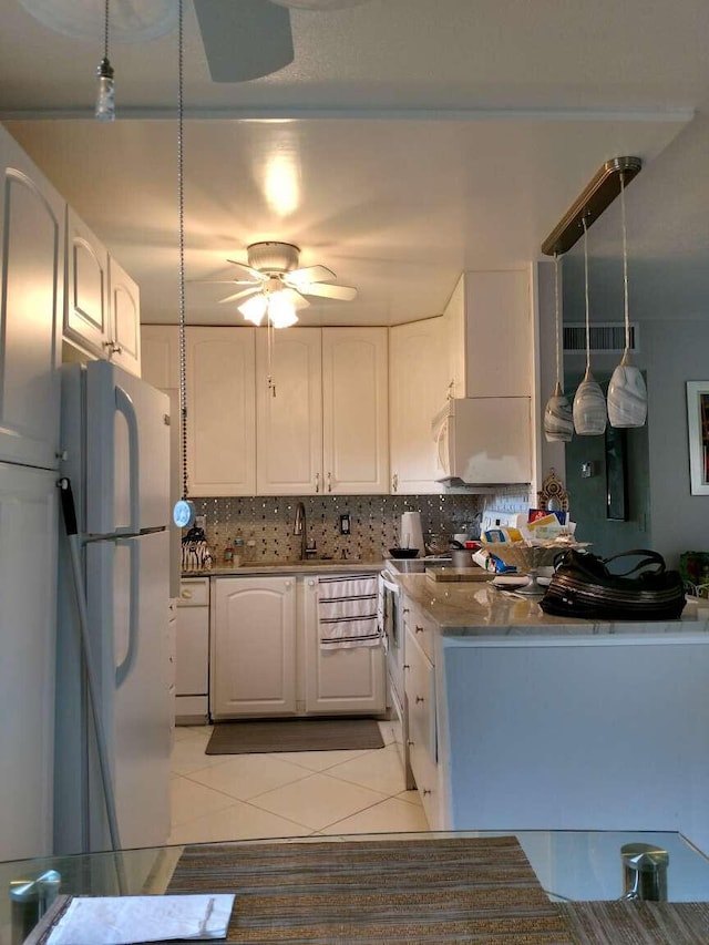 kitchen featuring white cabinets, light tile patterned floors, white appliances, and hanging light fixtures