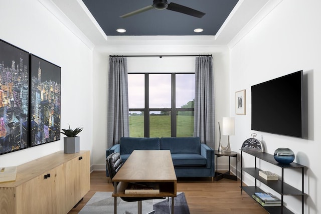 living room with hardwood / wood-style flooring, ceiling fan, and ornamental molding