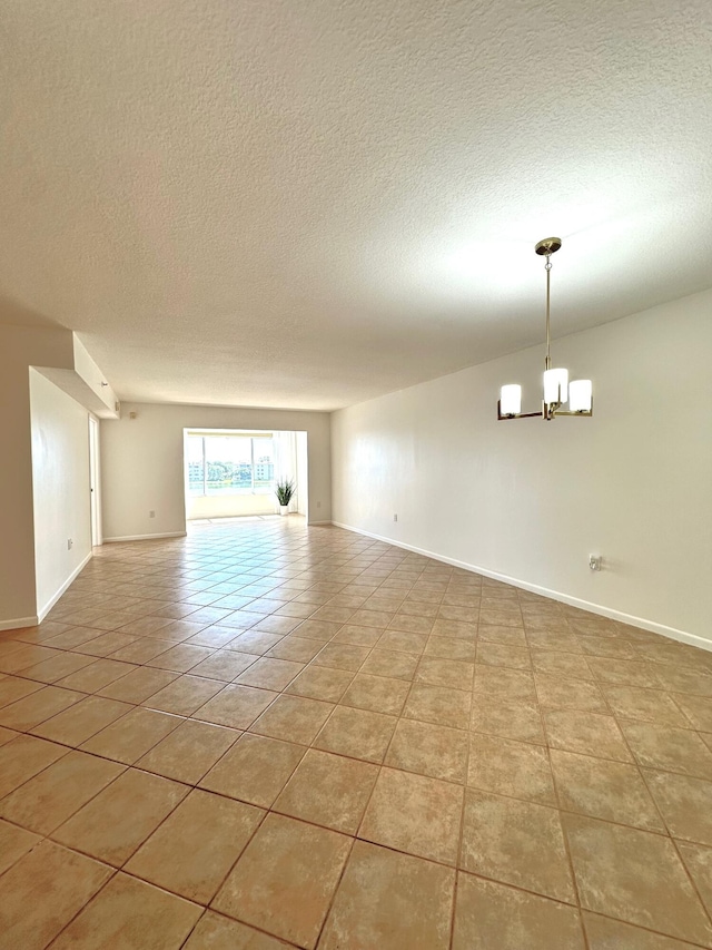 unfurnished living room featuring a notable chandelier, a textured ceiling, and light tile patterned floors