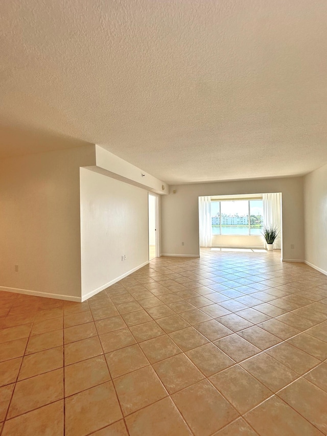 tiled empty room with a textured ceiling