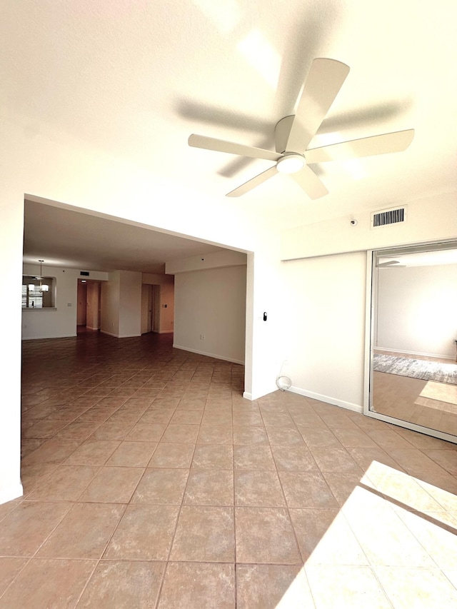 tiled spare room with ceiling fan