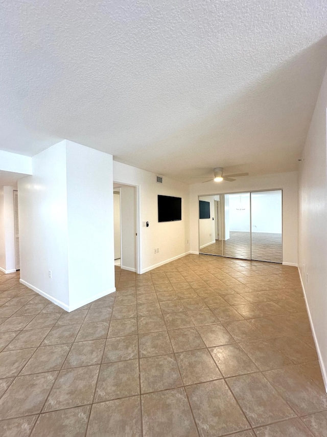 spare room featuring tile patterned flooring and a textured ceiling