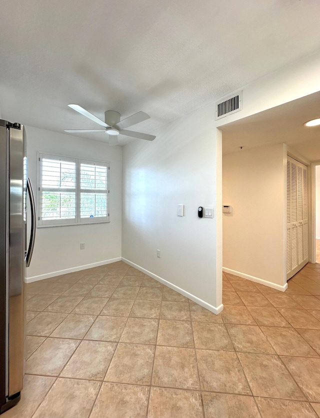 empty room with light tile patterned floors and ceiling fan