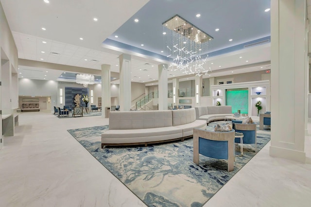 living room with a raised ceiling and a chandelier