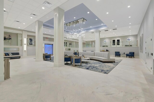 living room featuring a paneled ceiling and ornate columns