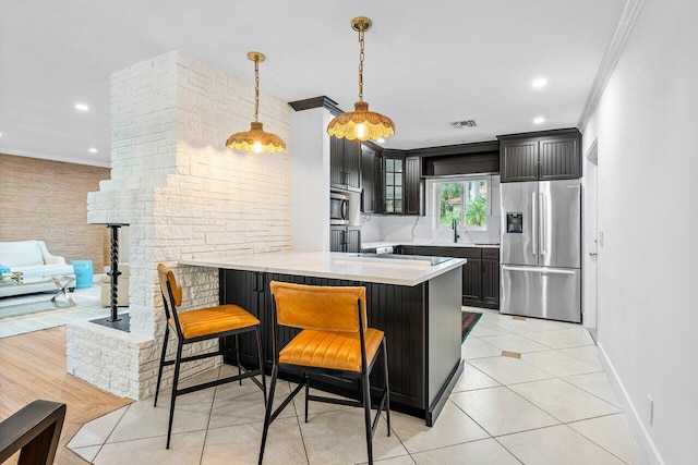 kitchen featuring kitchen peninsula, light tile patterned flooring, appliances with stainless steel finishes, a kitchen breakfast bar, and ornamental molding