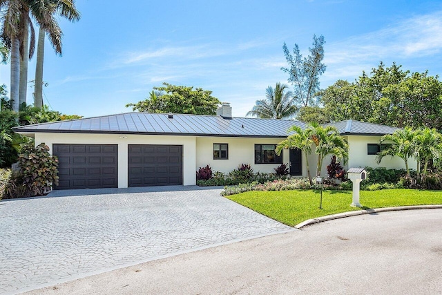 ranch-style house featuring a garage and a front yard