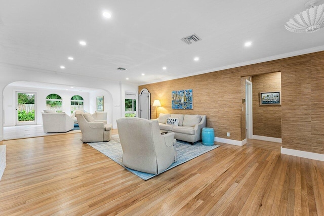 living room with a chandelier, crown molding, and light hardwood / wood-style floors