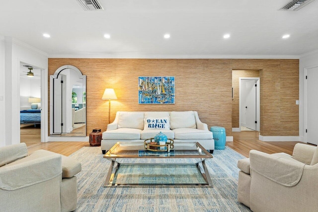 living room featuring ceiling fan, ornamental molding, and hardwood / wood-style flooring