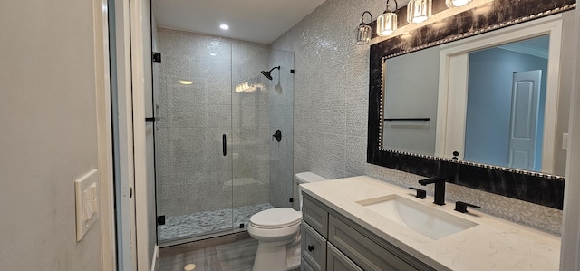 bathroom with vanity, a shower with shower door, and toilet