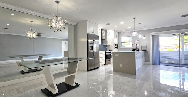 kitchen with appliances with stainless steel finishes, pendant lighting, white cabinets, a chandelier, and a kitchen island