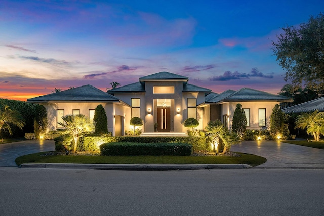 prairie-style home with decorative driveway and stucco siding