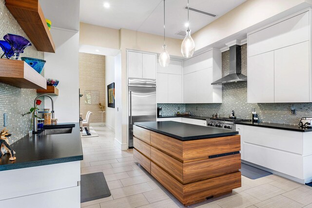 kitchen featuring white cabinetry, sink, wall chimney range hood, and stainless steel appliances