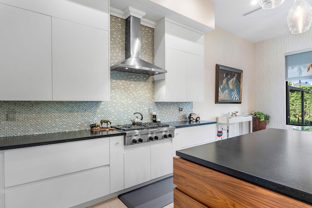 kitchen featuring backsplash, white cabinets, wall chimney exhaust hood, and stainless steel gas stovetop