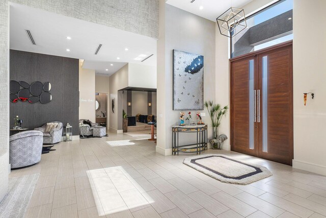 entryway with a high ceiling and a notable chandelier