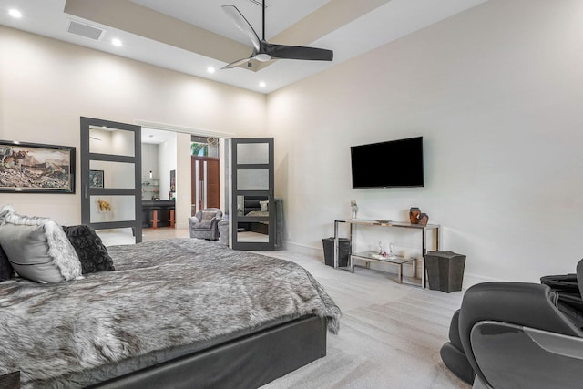 bedroom with light carpet, a high ceiling, and ceiling fan