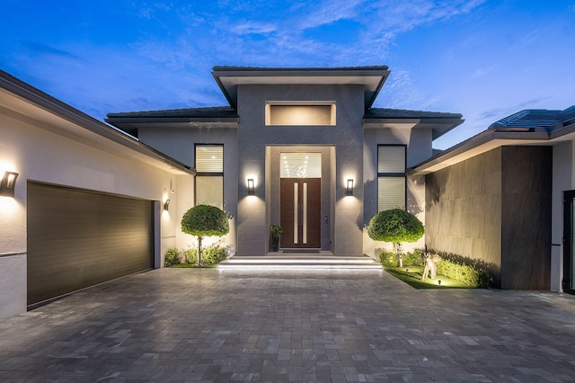 exterior entry at dusk with a garage