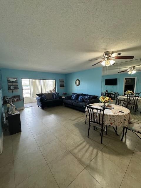 tiled dining space with ceiling fan and a textured ceiling