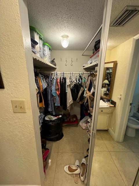 walk in closet featuring light tile flooring