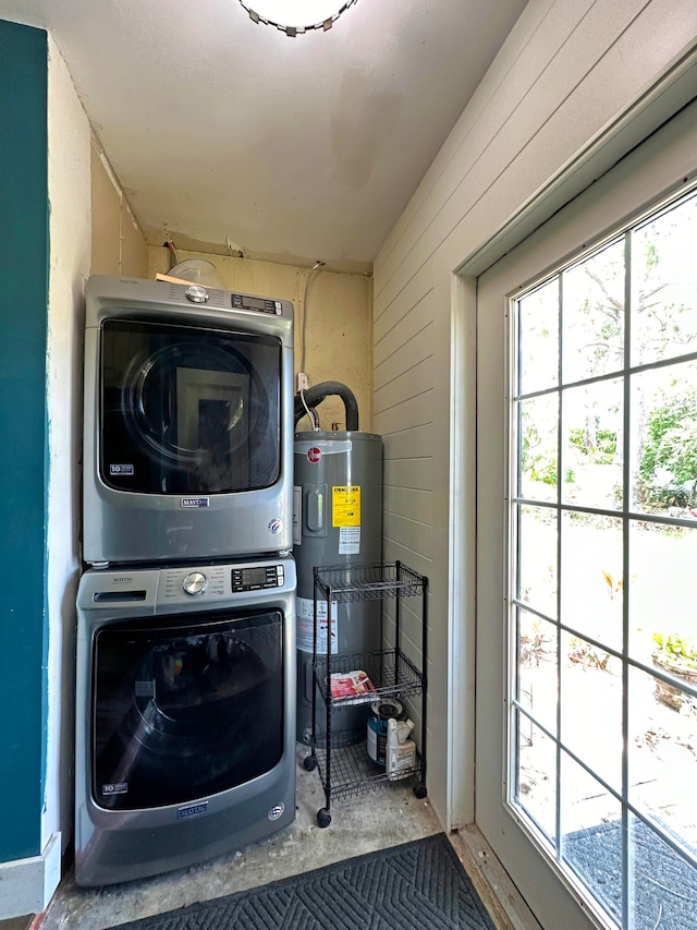 laundry area featuring stacked washer / drying machine and water heater