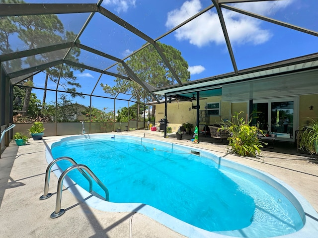 view of swimming pool featuring a patio and glass enclosure