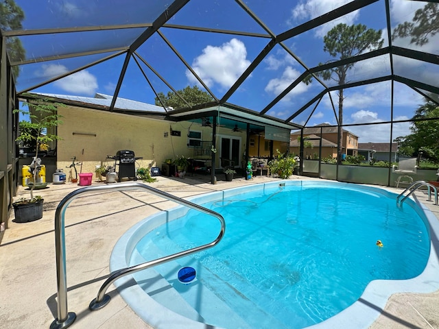 view of swimming pool featuring grilling area, glass enclosure, and a patio area