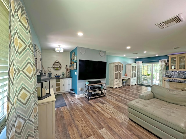 kitchen with decorative light fixtures, backsplash, stainless steel dishwasher, dark stone countertops, and sink