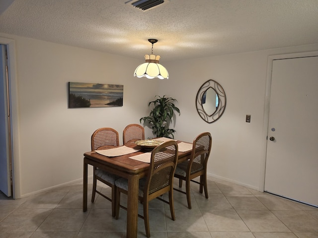 dining space featuring light tile patterned floors and a textured ceiling