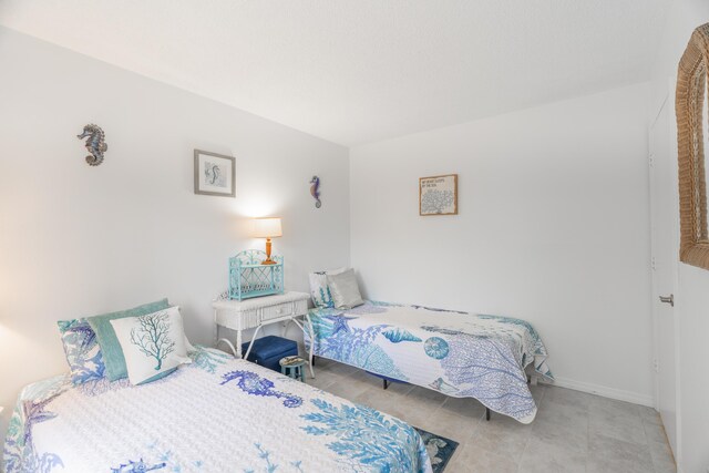 tiled bedroom featuring baseboards