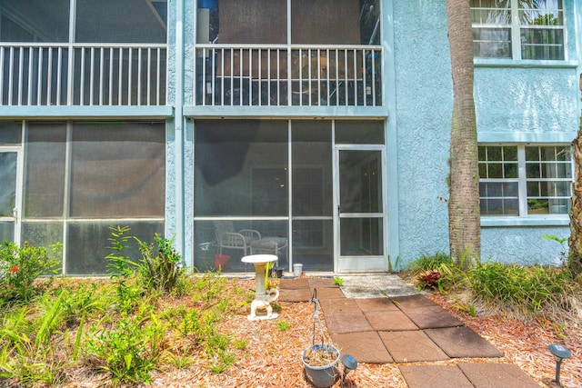 exterior space with stucco siding and a balcony