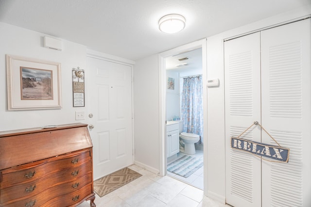 bathroom with vanity, baseboards, tile patterned flooring, curtained shower, and toilet