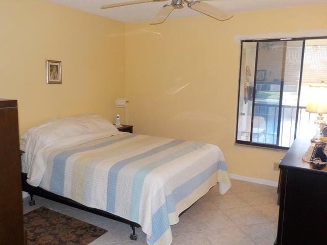 tiled bedroom featuring ceiling fan