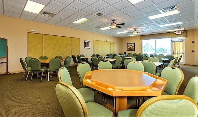 carpeted dining room with a paneled ceiling and ceiling fan