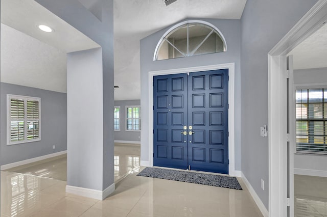 tiled foyer entrance featuring lofted ceiling