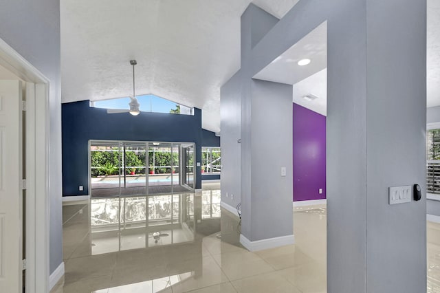 interior space featuring high vaulted ceiling, ceiling fan, and light tile patterned floors