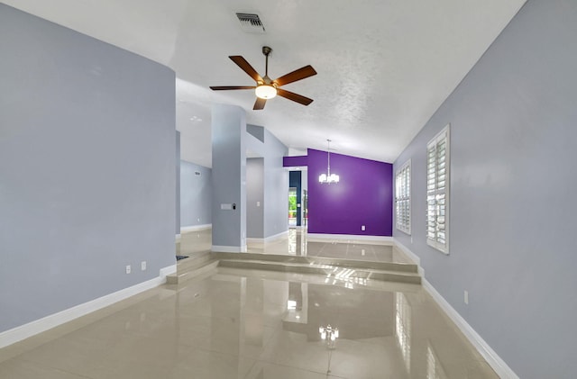 tiled spare room featuring a textured ceiling, ceiling fan with notable chandelier, and vaulted ceiling