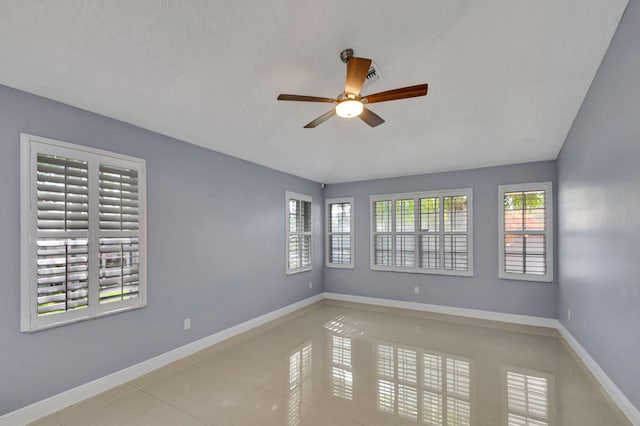 tiled empty room featuring a wealth of natural light and ceiling fan