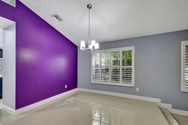 unfurnished dining area featuring tile patterned floors, a textured ceiling, vaulted ceiling, and a chandelier