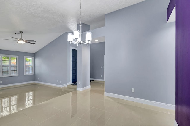 tiled empty room with a textured ceiling, ceiling fan with notable chandelier, and vaulted ceiling