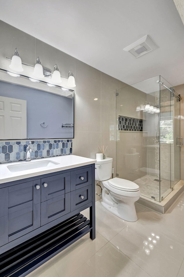 bathroom featuring tile walls, decorative backsplash, toilet, tile patterned floors, and vanity