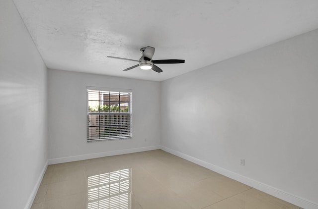 spare room featuring ceiling fan and light tile patterned floors