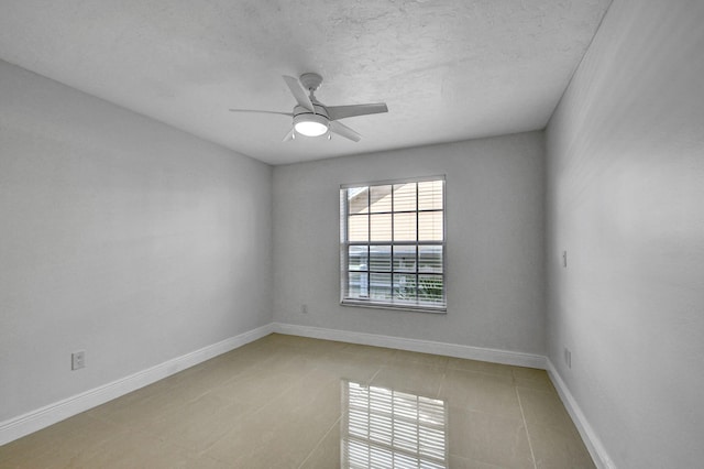 tiled spare room with a textured ceiling and ceiling fan