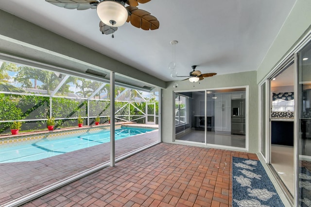 view of swimming pool with a patio, ceiling fan, and glass enclosure