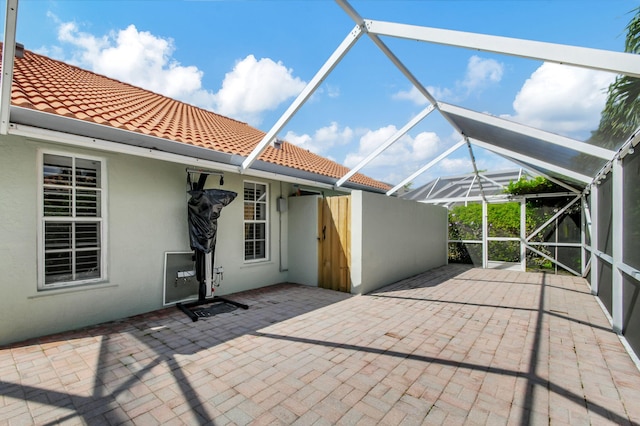 exterior space featuring a patio area and glass enclosure